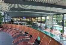 Ruhebereich mit vielen Liegestühlen und Pool unter Kristallkronleuchtern
