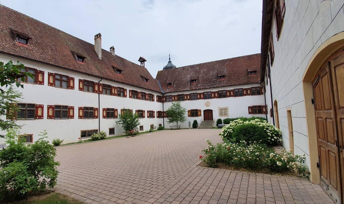 Gepflasterter Innenhof mit schön gepflegtem Klostergebäude