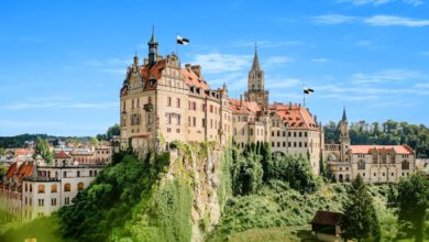 Schloss Sigmaringen auf Kalkfelsen thronend mit deutscher Flagge bei strahlendem Himmel