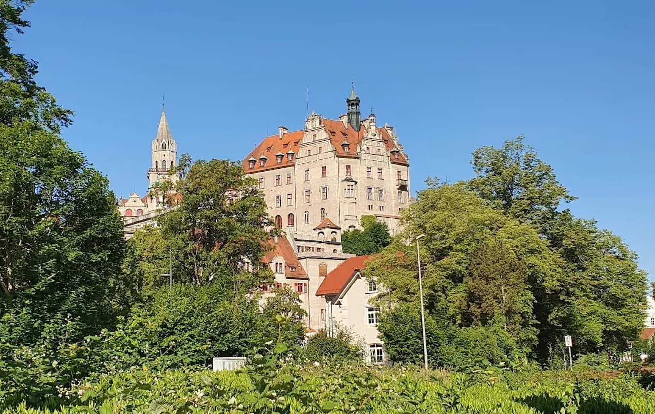 Schloss Sigmaringen umgeben von grünen Bäumen und Gärten in der Fernsicht
