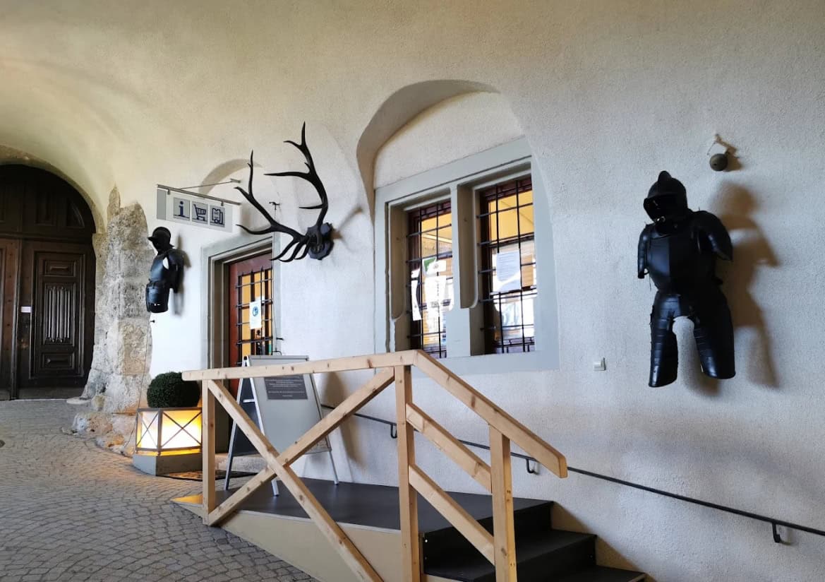 Mittelalterlicher Korridor mit historischen Rüstungen und Geweih an weißen Gewölbewänden im Schloss Sigmaringen