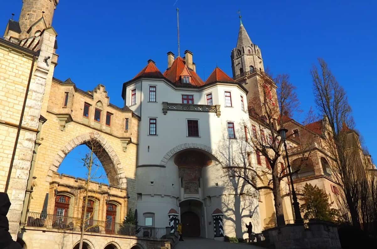 Schloss Sigmaringen Außenansicht mit gotischen Türmen und Steinbrücke bei blauem Himmel